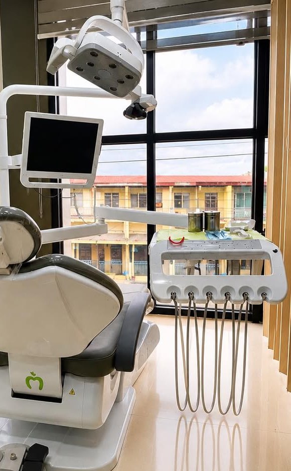 The treatment room at Denta Cure Dental Clinic with a modern dental chair and equipment